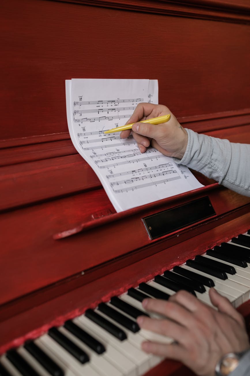 person writing on the sheet music