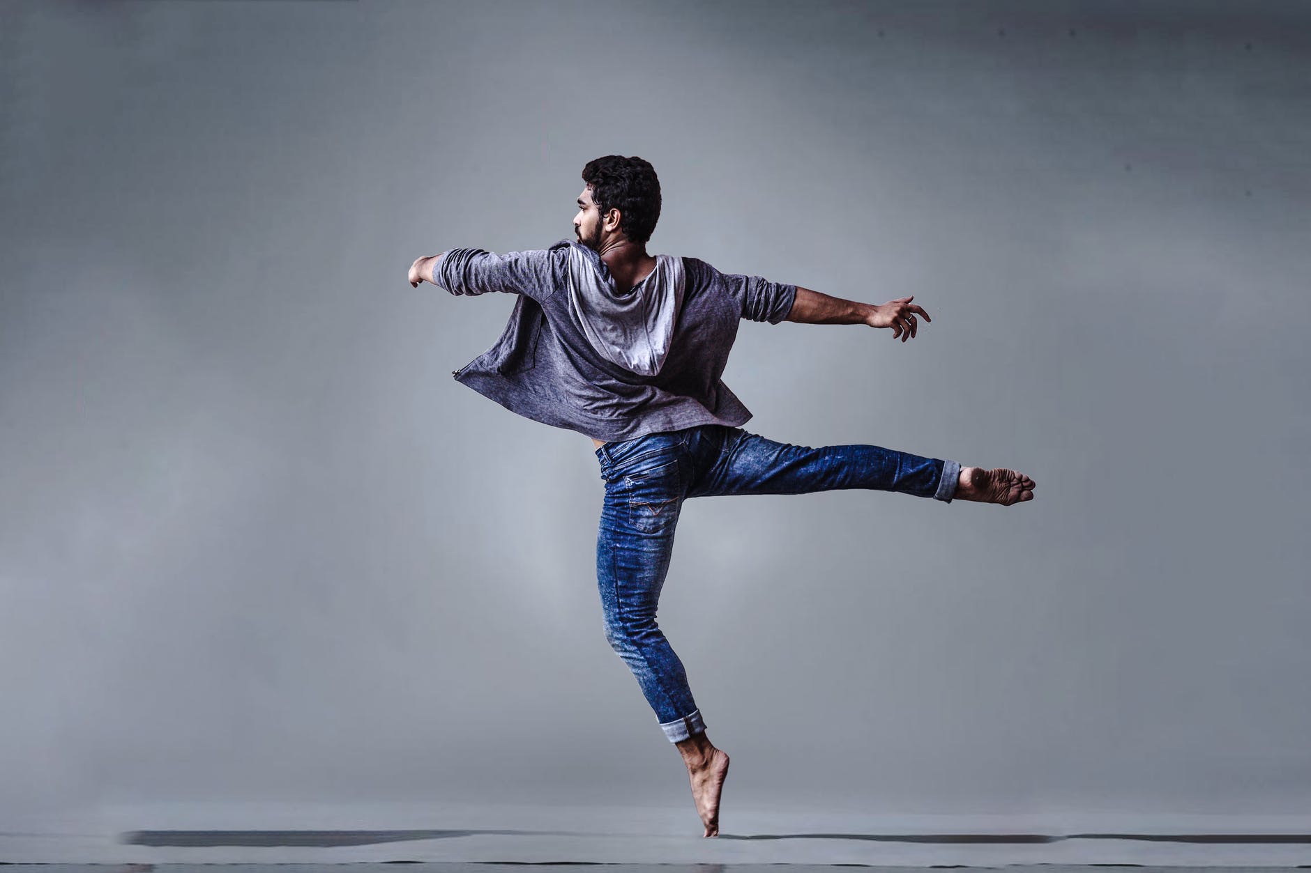 man wearing blue jeans doing pirouette spin